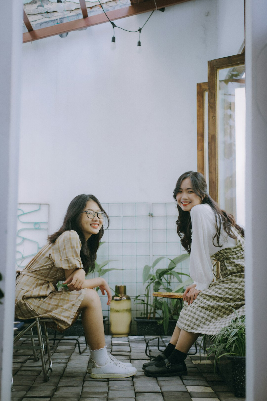Smiling friends sitting together and talking indoors